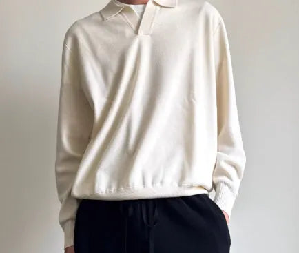 Man wearing a milky white pure wool polo sweater with a lapel collar in a loose fit.