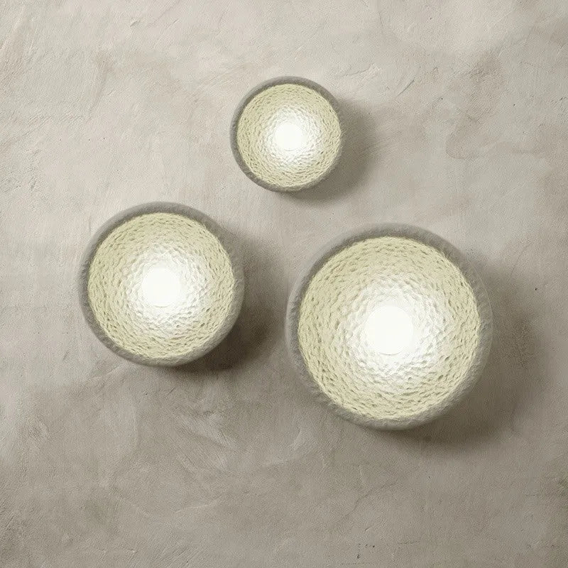 Japanese minimalist wall lamp in resin with warm light, showing three size options