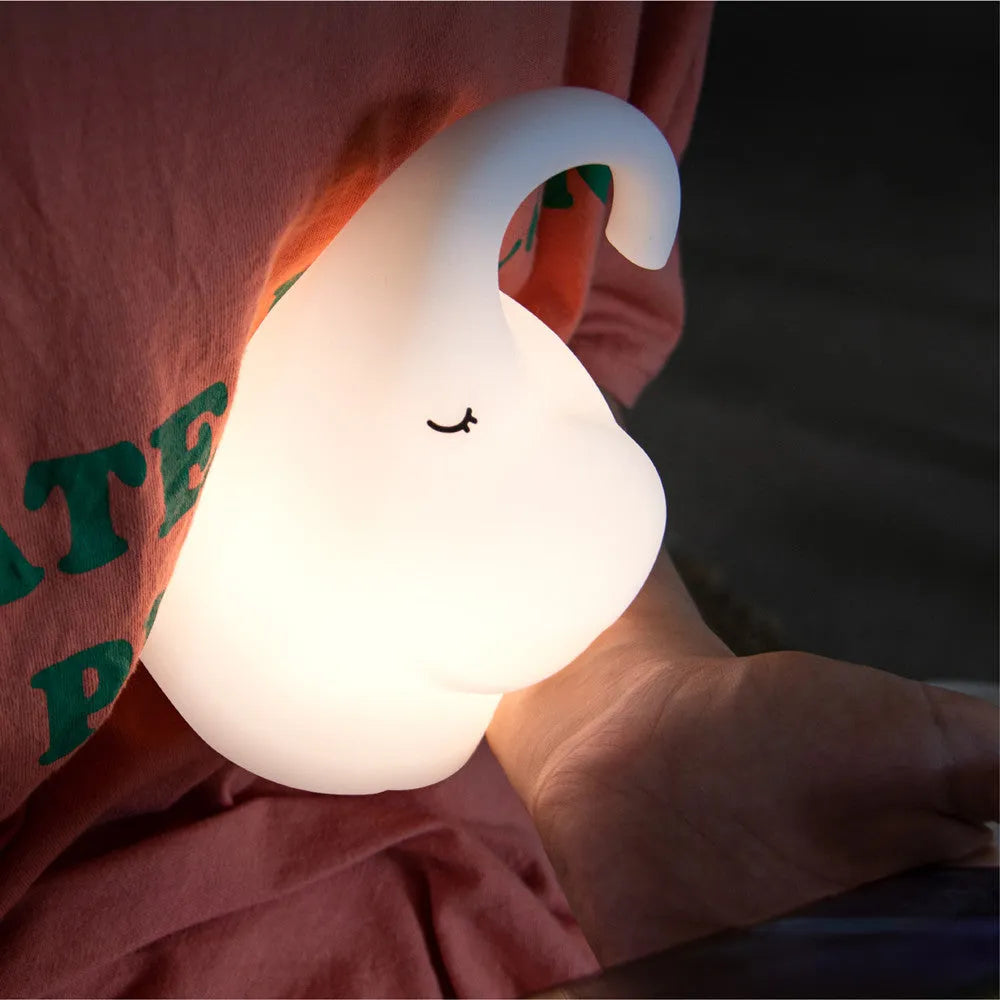 Elephant shaped silicone night light with warm 3000k LED glow on a bedside table