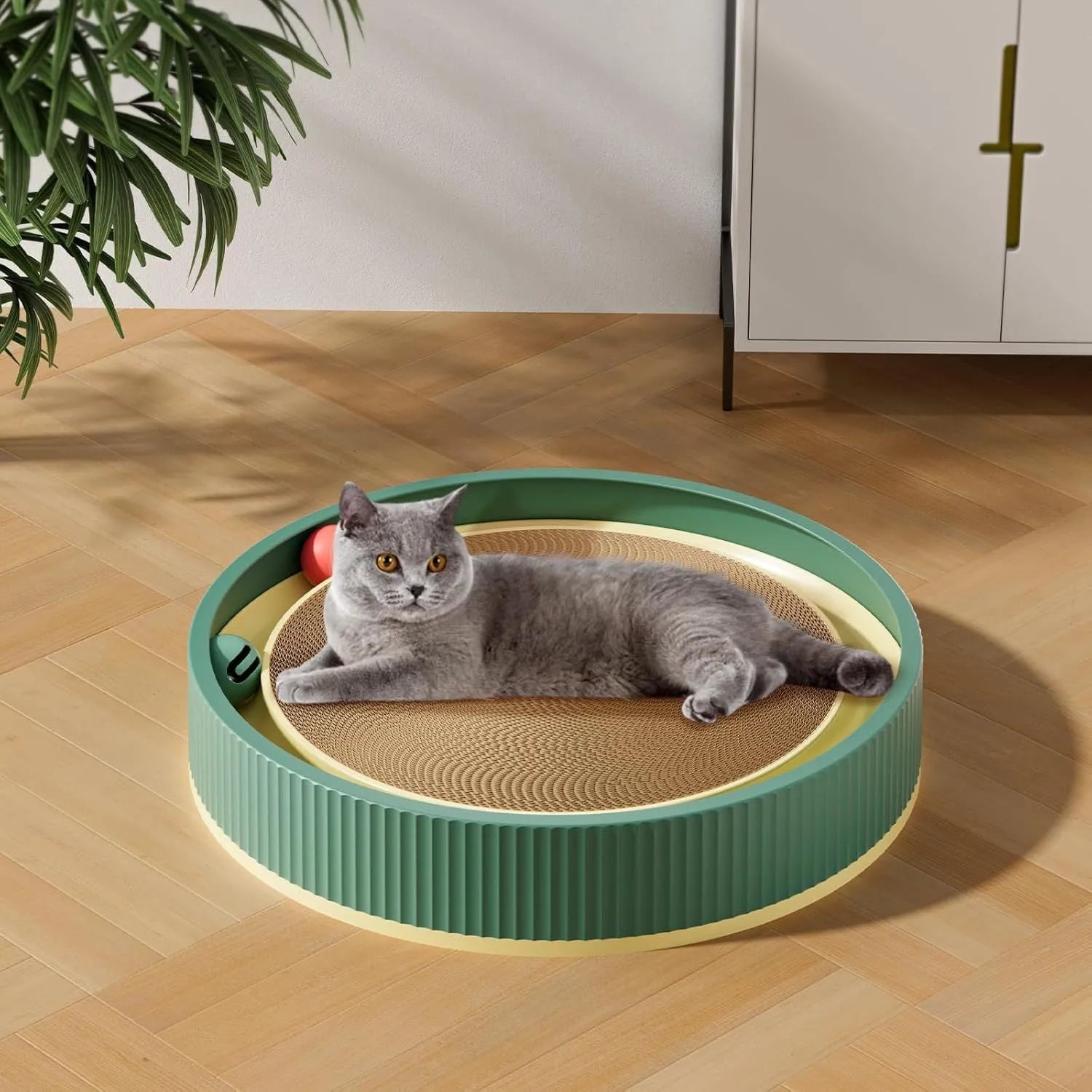 Large green cat scratching board with moving ball toys and a refillable cardboard core.
