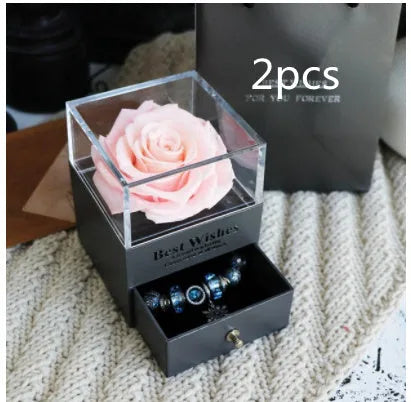 Glass eternal flower jewellery box with preserved roses and carnations inside measuring 8.5cm square