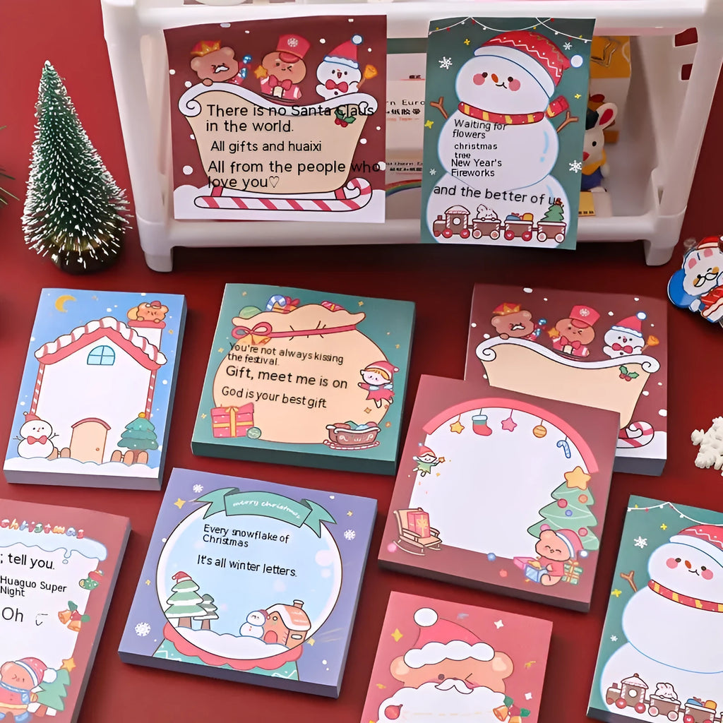Christmas sticky notes book with cartoon designs of Santa, snowman, elf, gift, house, sled, crystal ball, and bear