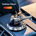 Silver metal solar helicopter car air freshener ornament with rotating blades on dashboard