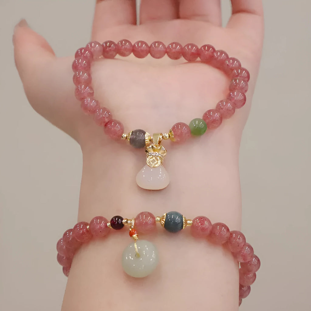 Women's strawberry quartz bracelet with geometric charm, purse charm, and safety buckle.