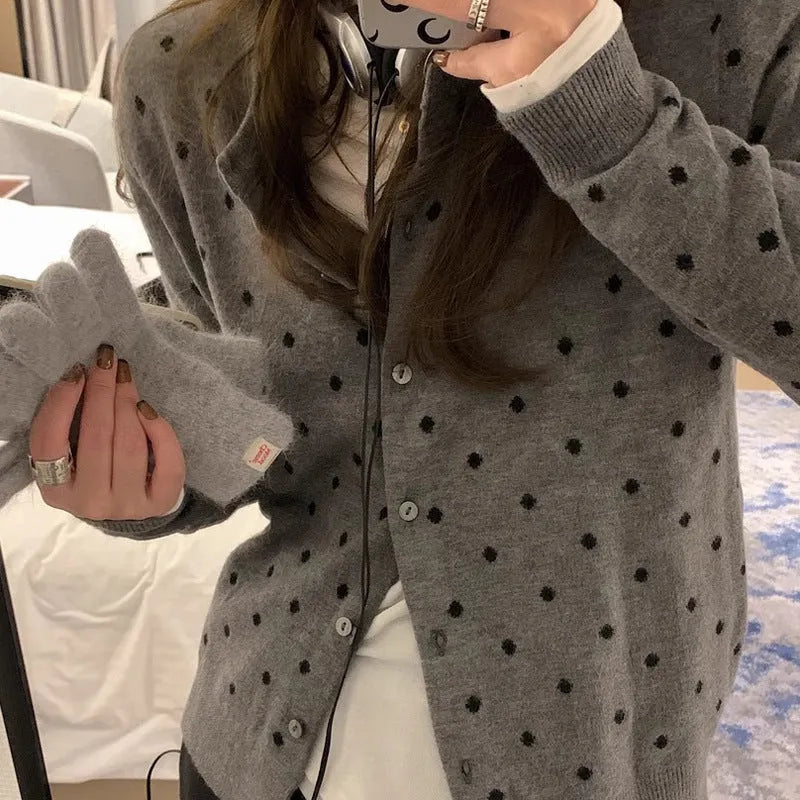 Women's loose fit grey dot knitted cardigan with crocheted flower trim on long sleeves.