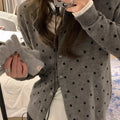 Women's loose fit grey dot knitted cardigan with crocheted flower trim on long sleeves.
