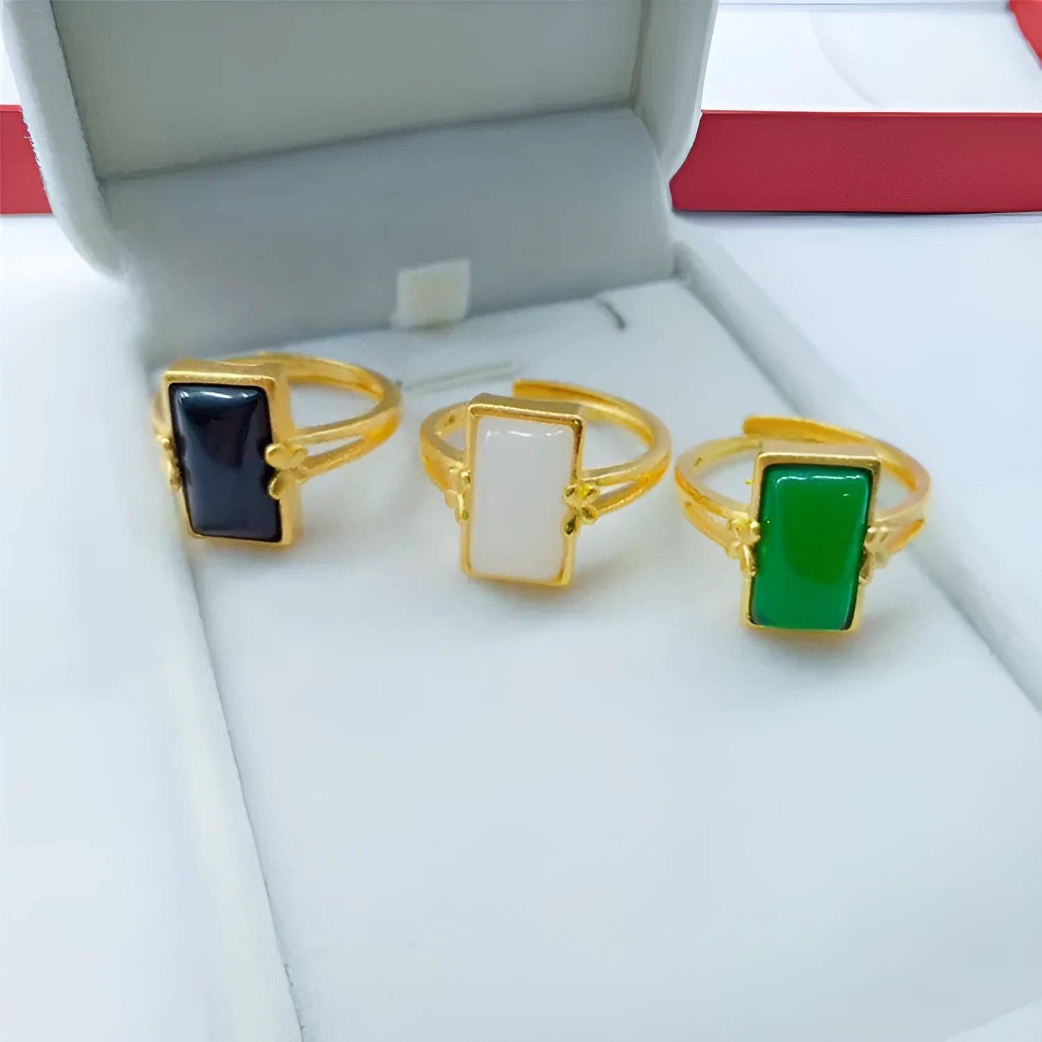 Adjustable brass gold-plated ring with a central electroplated gemstone, shown in black, green, and white colour options.