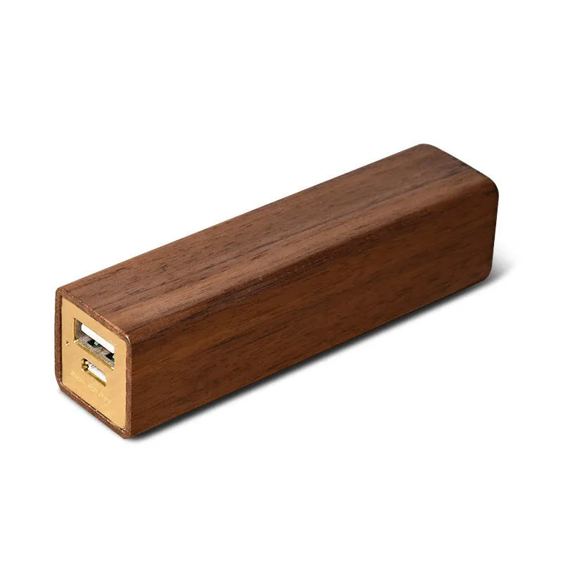 Brown walnut wood portable power bank with USB port next to its gift box.