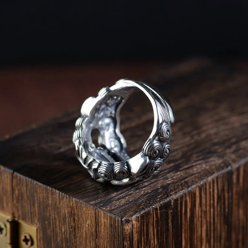 Silver open ring with a detailed domineering Jibeast animal pattern on a model's finger.