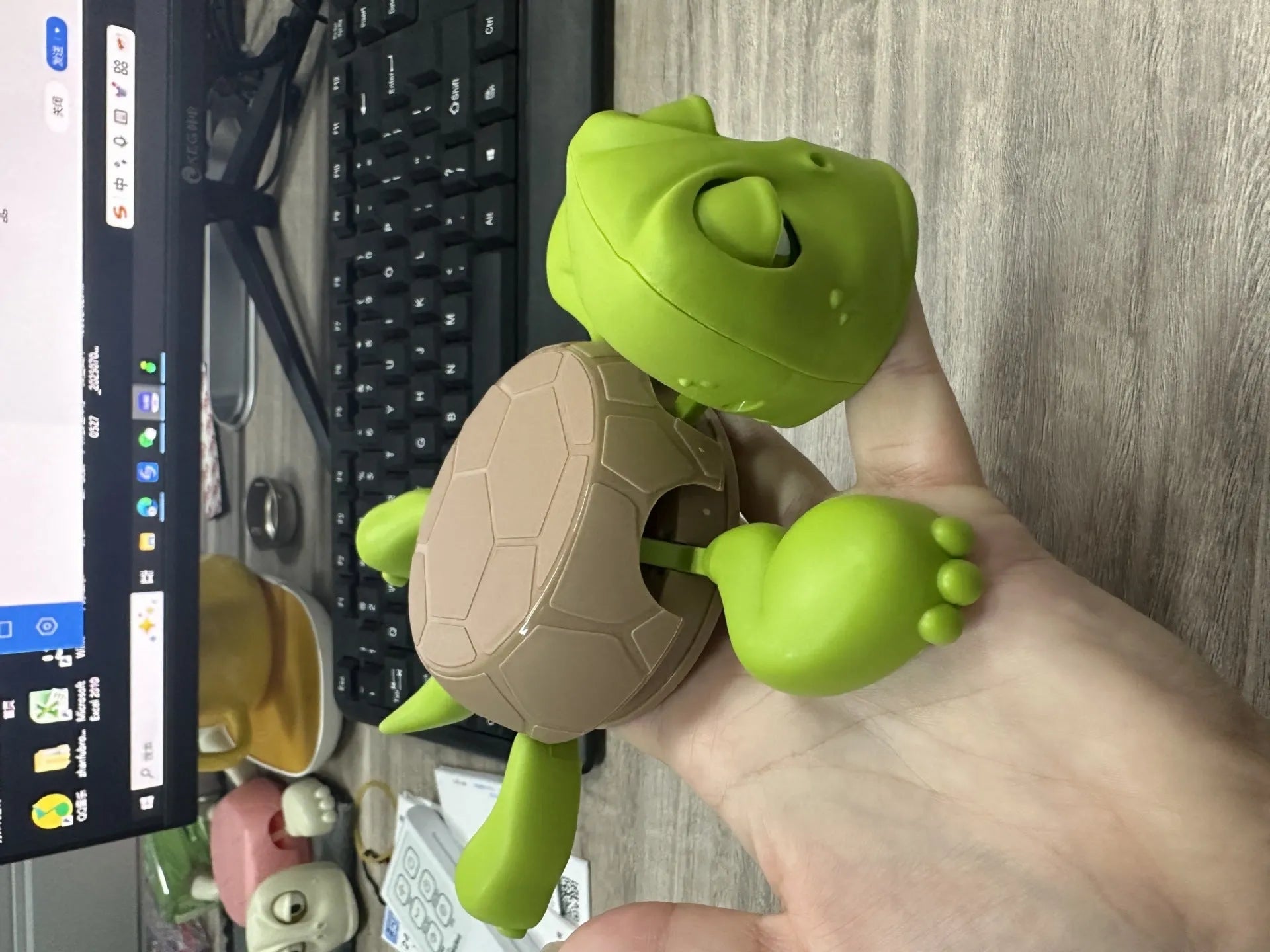 Creative turtle-shaped ABS plastic coaster in green on a wooden table.