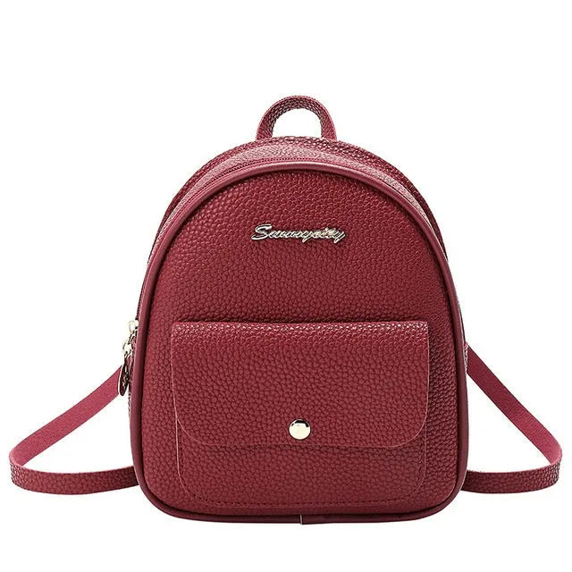 Small black PU leather women's shoulder backpack with a zipper, shown next to a mobile phone for scale.