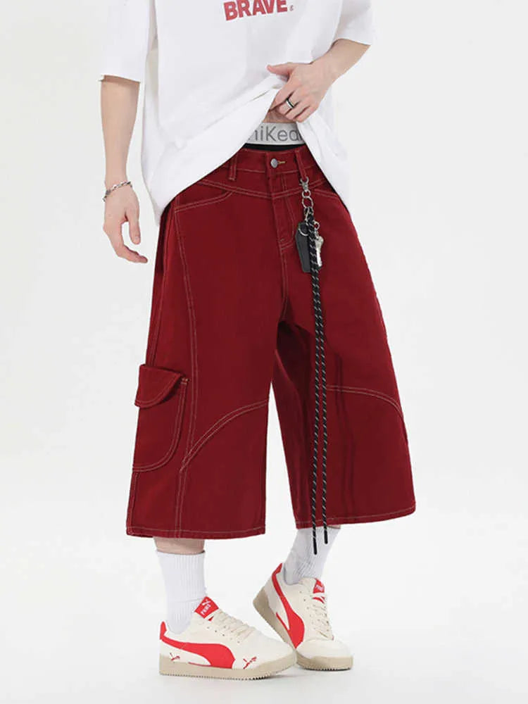 Red denim retro workwear shorts with multiple pockets and a wide-leg cropped fit on a model.