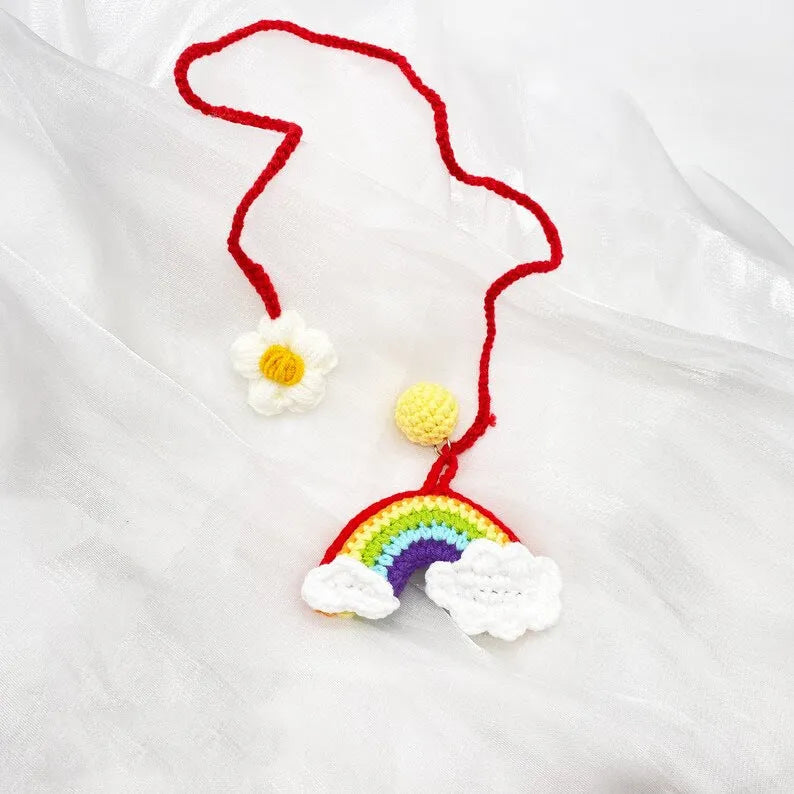 Handmade crocheted avocado with rainbow flower car pendant in wool yarn.