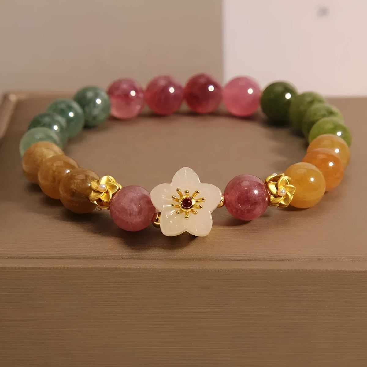 Natural tourmaline bracelet with flower and Fu charms on silver-tone electroplated brass.