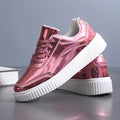 Rose gold sequin platform sneaker with thick sole and round toe on a white background.