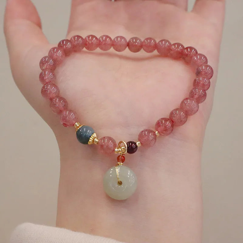 Women's strawberry quartz bracelet with geometric charm, purse charm, and safety buckle.