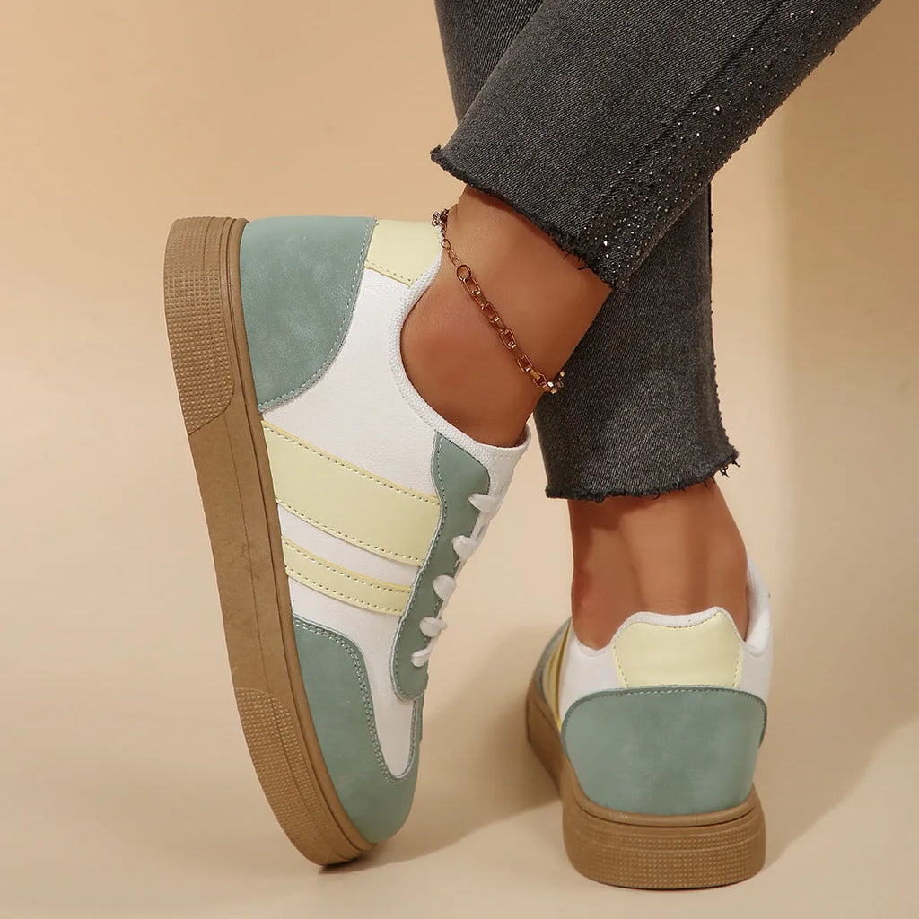 Green women's retro sports pumps with cross straps and leather stitching details