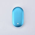 Rose gold rechargeable mini hand warmer and USB power bank two-in-one unit on a table.