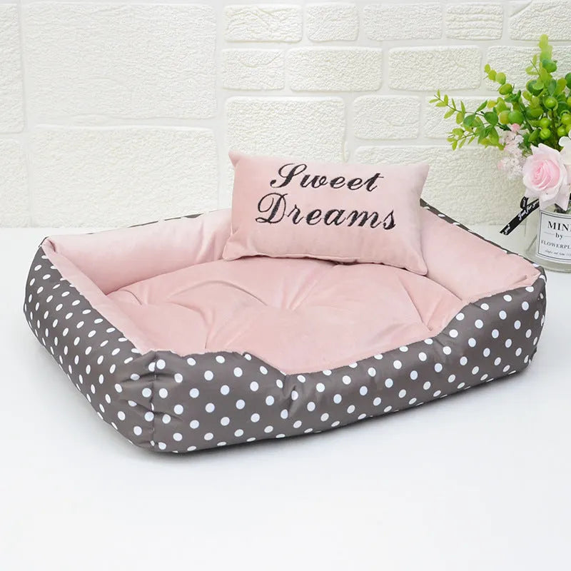 Polka dot printed cloth dog bed with matching embroidery pillow in grey, shown in a room setting.