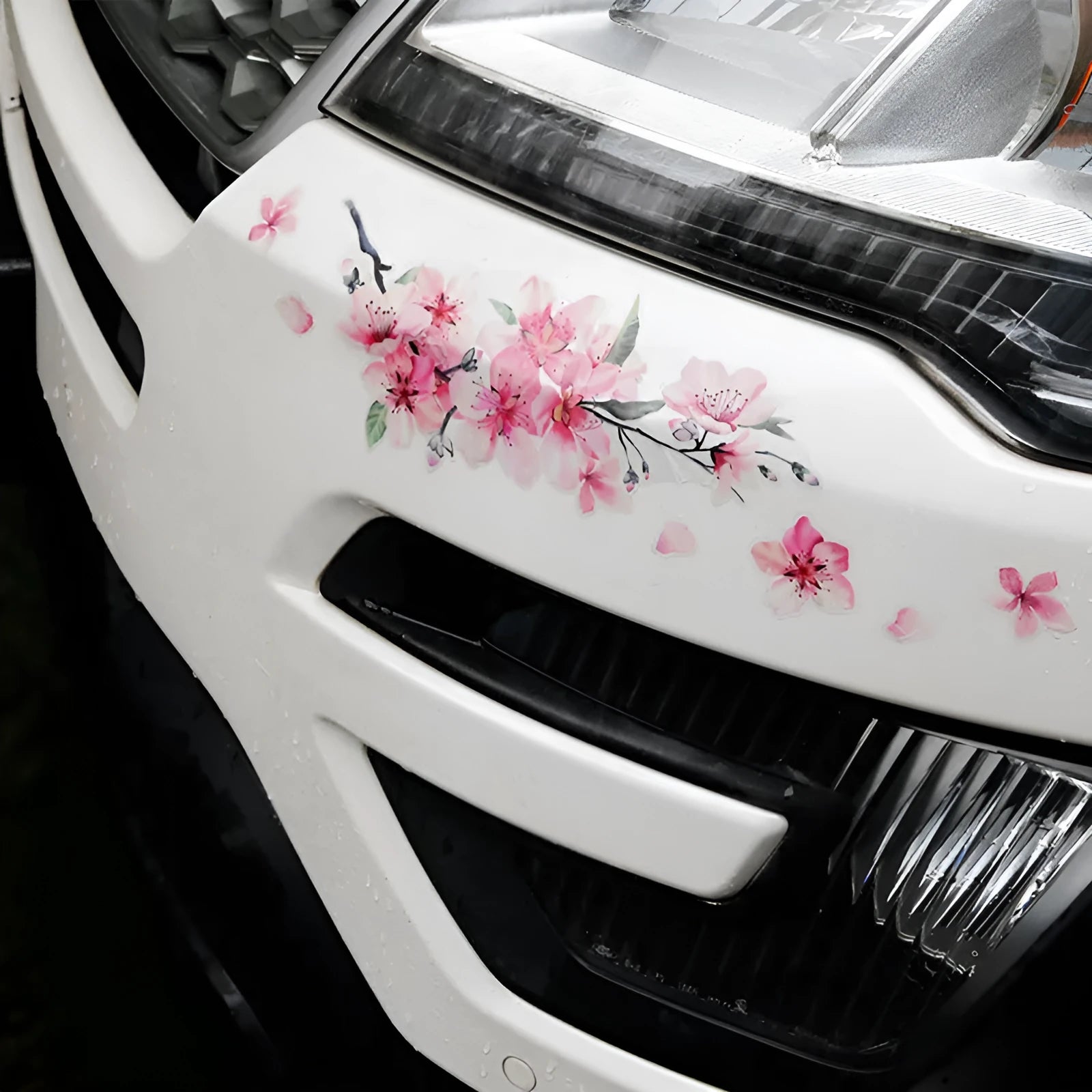 Close-up of a pink and white cherry blossom car sticker on a clear PVC backing.
