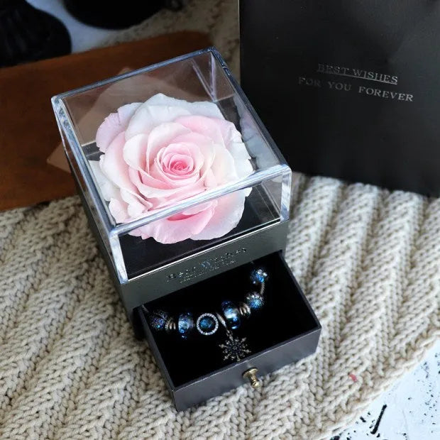 Glass eternal flower jewellery box with preserved roses and carnations inside measuring 8.5cm square