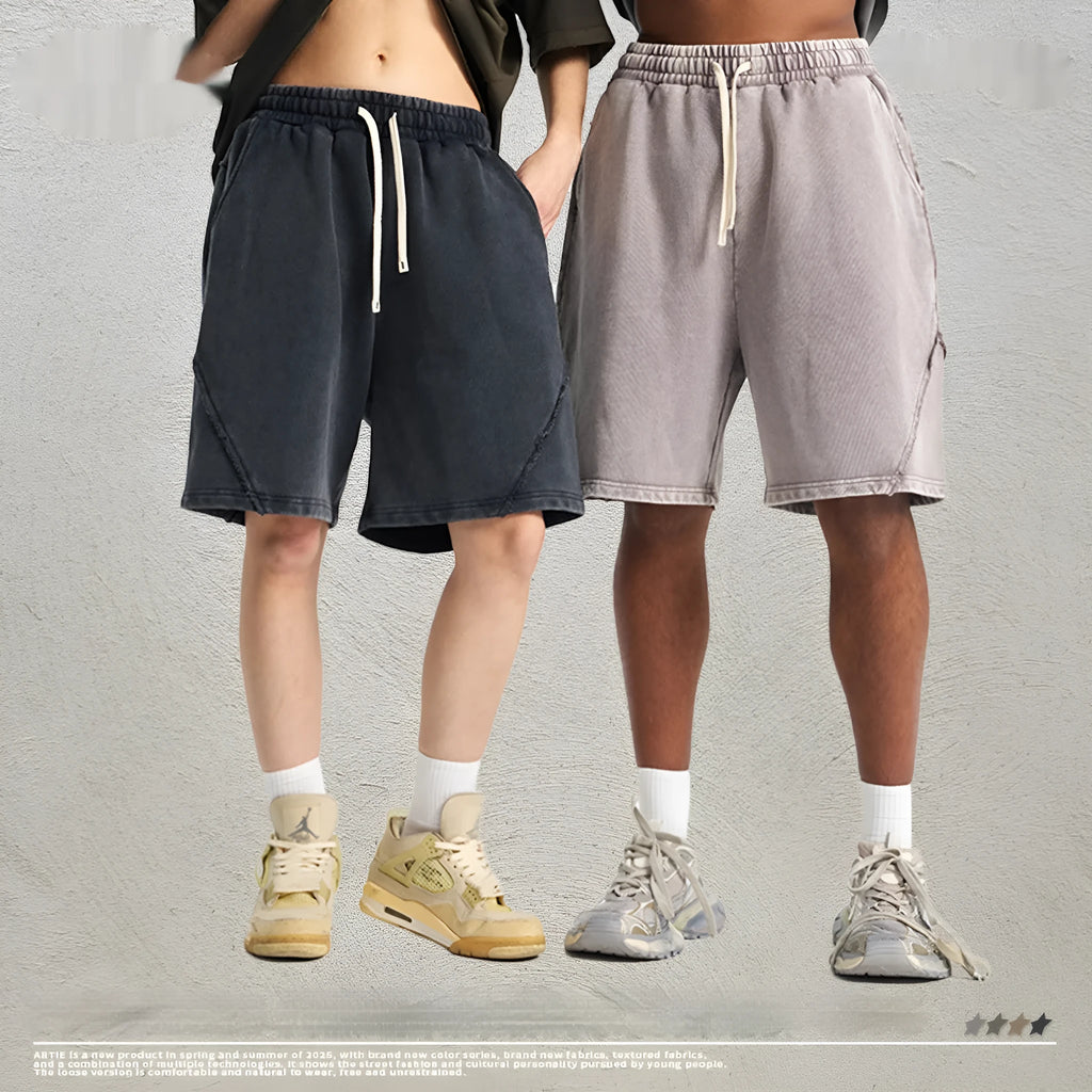 Man wearing batik washed black cotton terry shorts in a loose, street-fashion style.