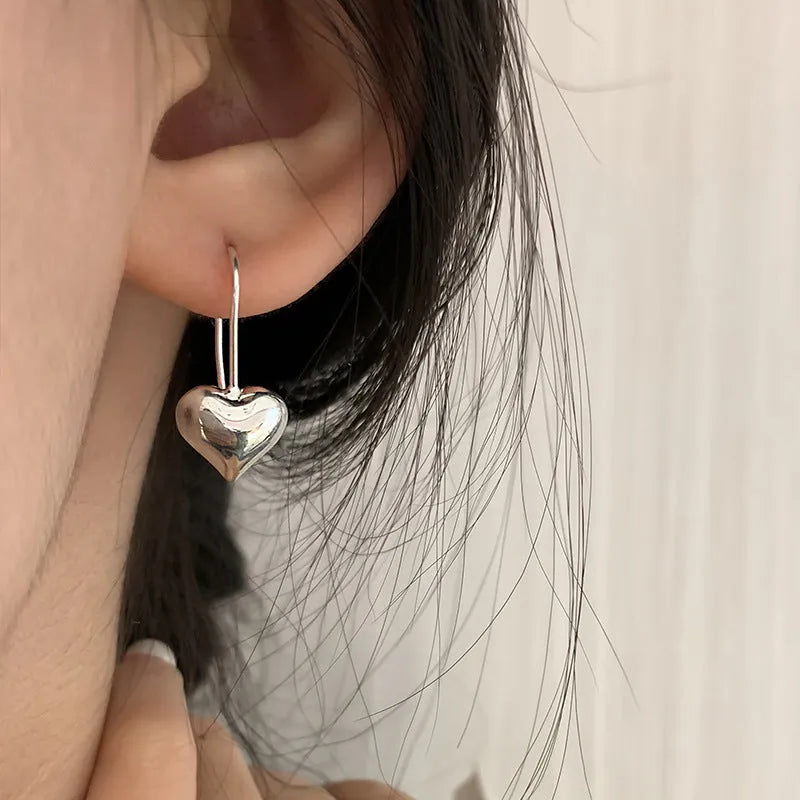 Three-dimensional copper heart earrings with glossy finish and Korean-style design