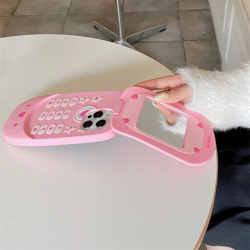 Light pink silicone flip phone case with a built-in mirror, open and showing iPhone model compatibility.