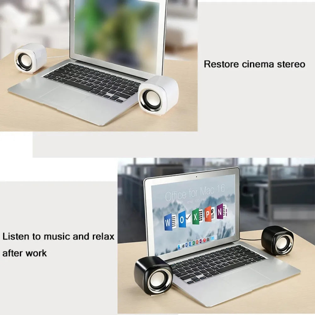 Pair of mini desktop speakers with 3.5mm audio plug on desk beside laptop