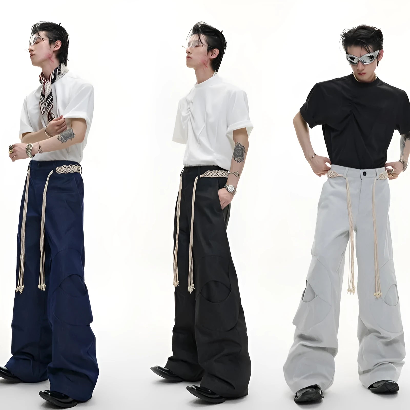 Man wearing dark grey straight-leg cotton trousers with a tassel detail and loose fit.