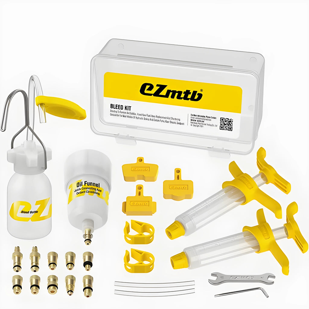 EZmtb bicycle hydraulic brake bleed kit showing syringes, metal fittings, adapters, and tools on a workbench.