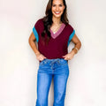 Burgundy women's V-neck sweater with white trim on collar and short sleeve cuffs