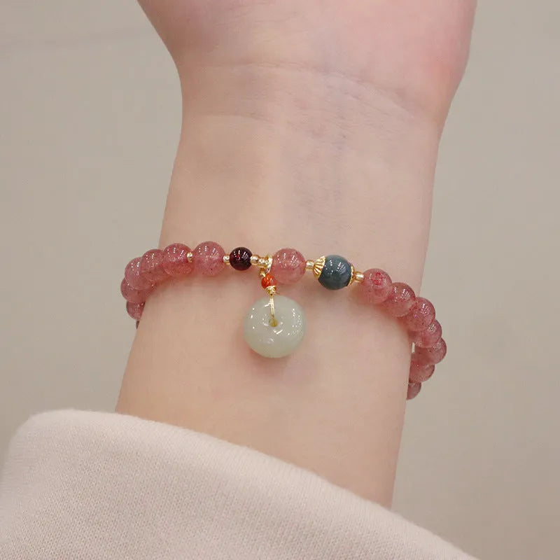 Women's strawberry quartz bracelet with geometric charm, purse charm, and safety buckle.