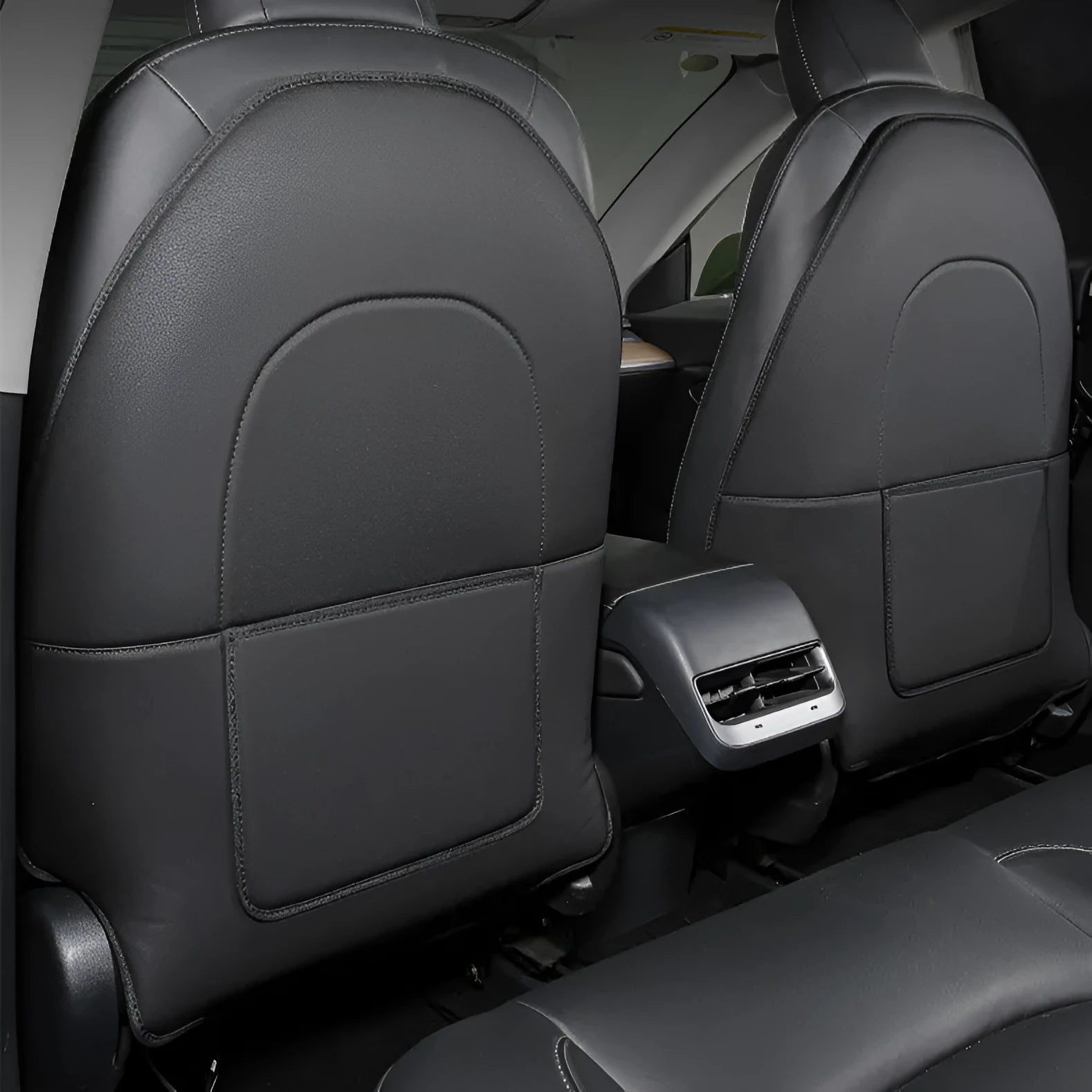 Two black leather motorcycle seat anti kick pads showing size and texture.
