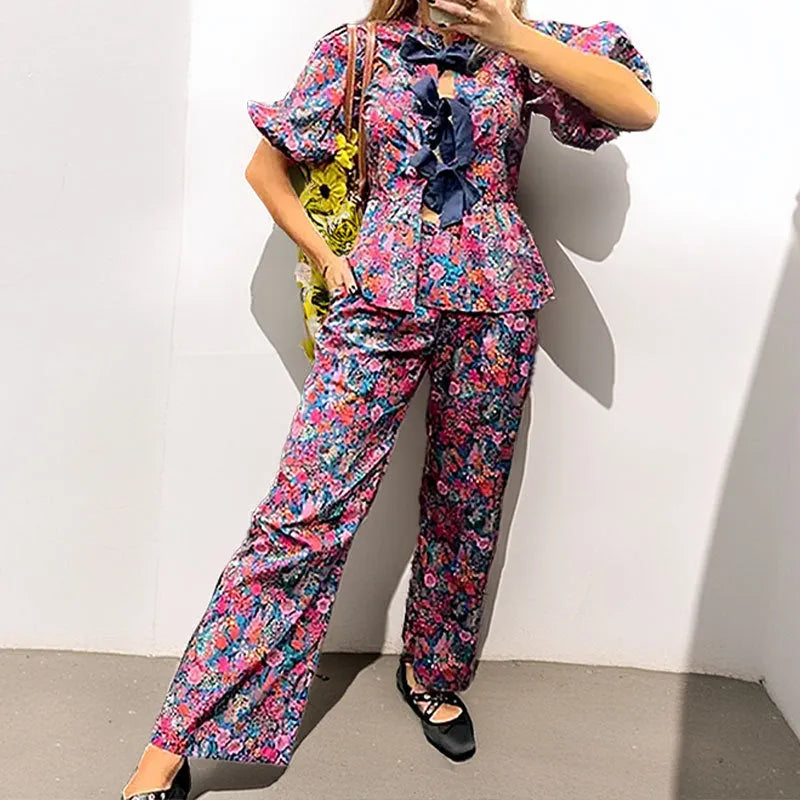 Floral print trousers suit with tie-neck top and puff sleeves, matching two-piece set