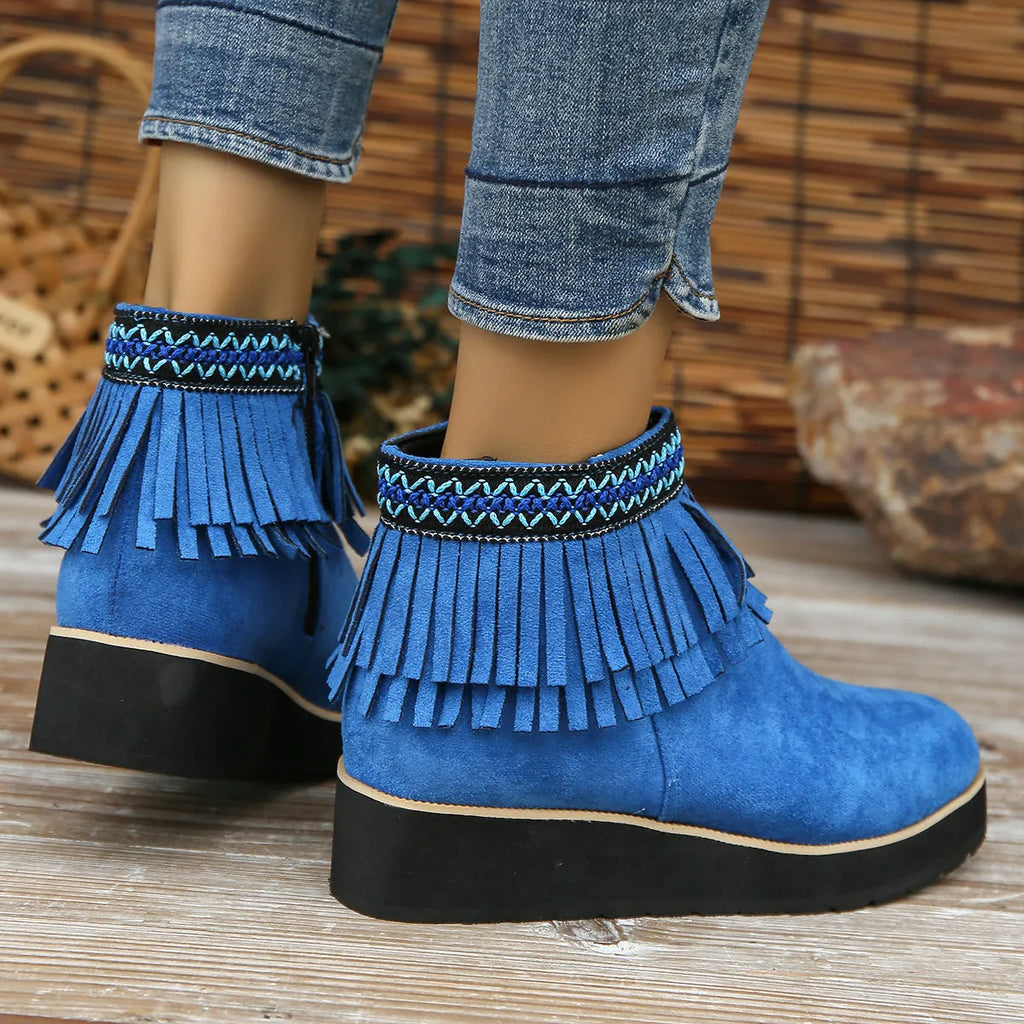 Women's black suede wedge ankle boot with side zip, tassel, and thick rubber sole.