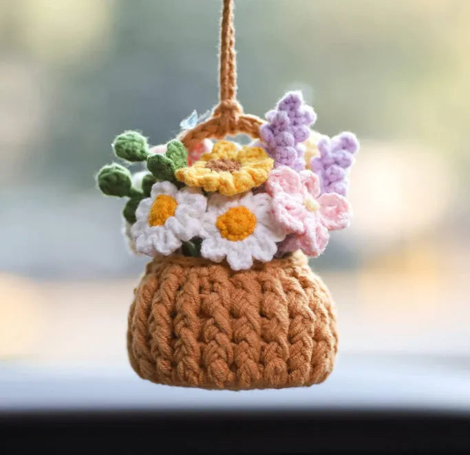 Green and white knitted wool car plant decoration basket with white hanging cord.