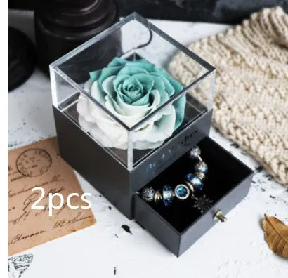Glass eternal flower jewellery box with preserved roses and carnations inside measuring 8.5cm square