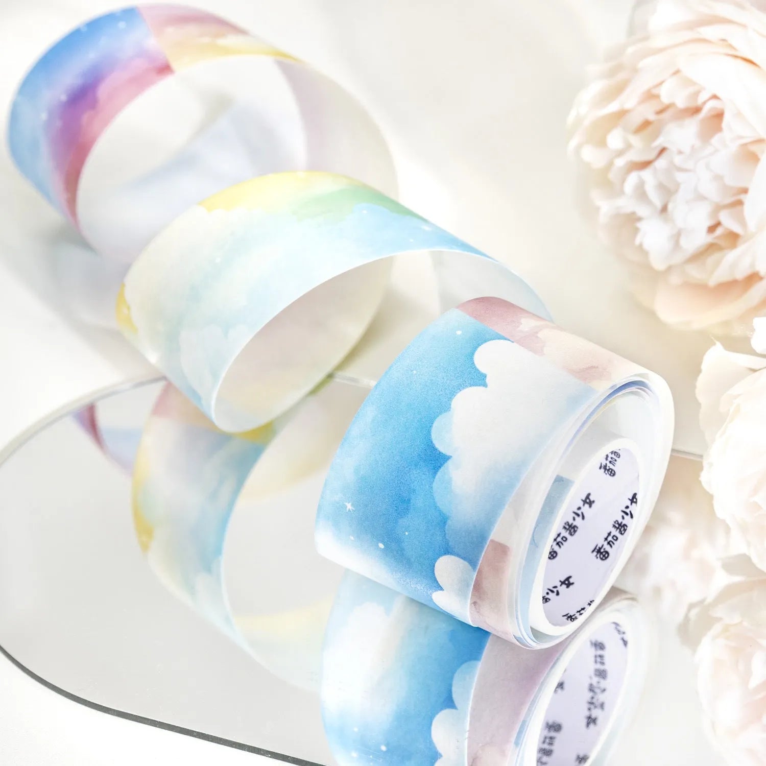 Roll of 30mm wide sky-themed Japanese paper washi tape showing colourful cloud design