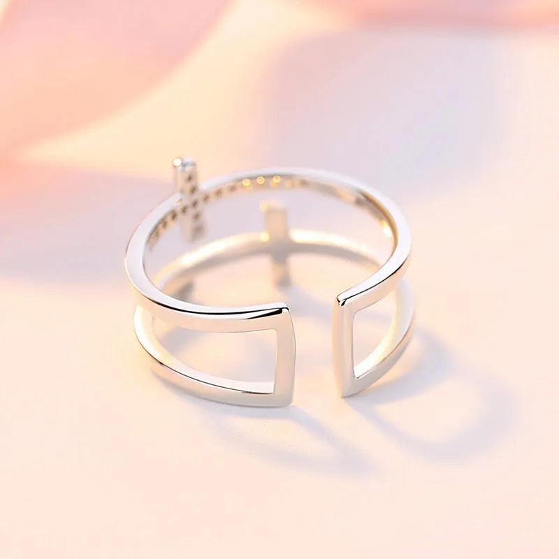 Women's double cross geometric open ring with zircon inlay on copper, showing adjustable opening.