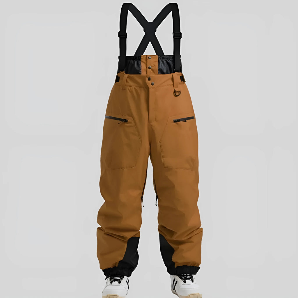 Man wearing black waterproof ski trousers with an adjustable strap, on a ski slope.