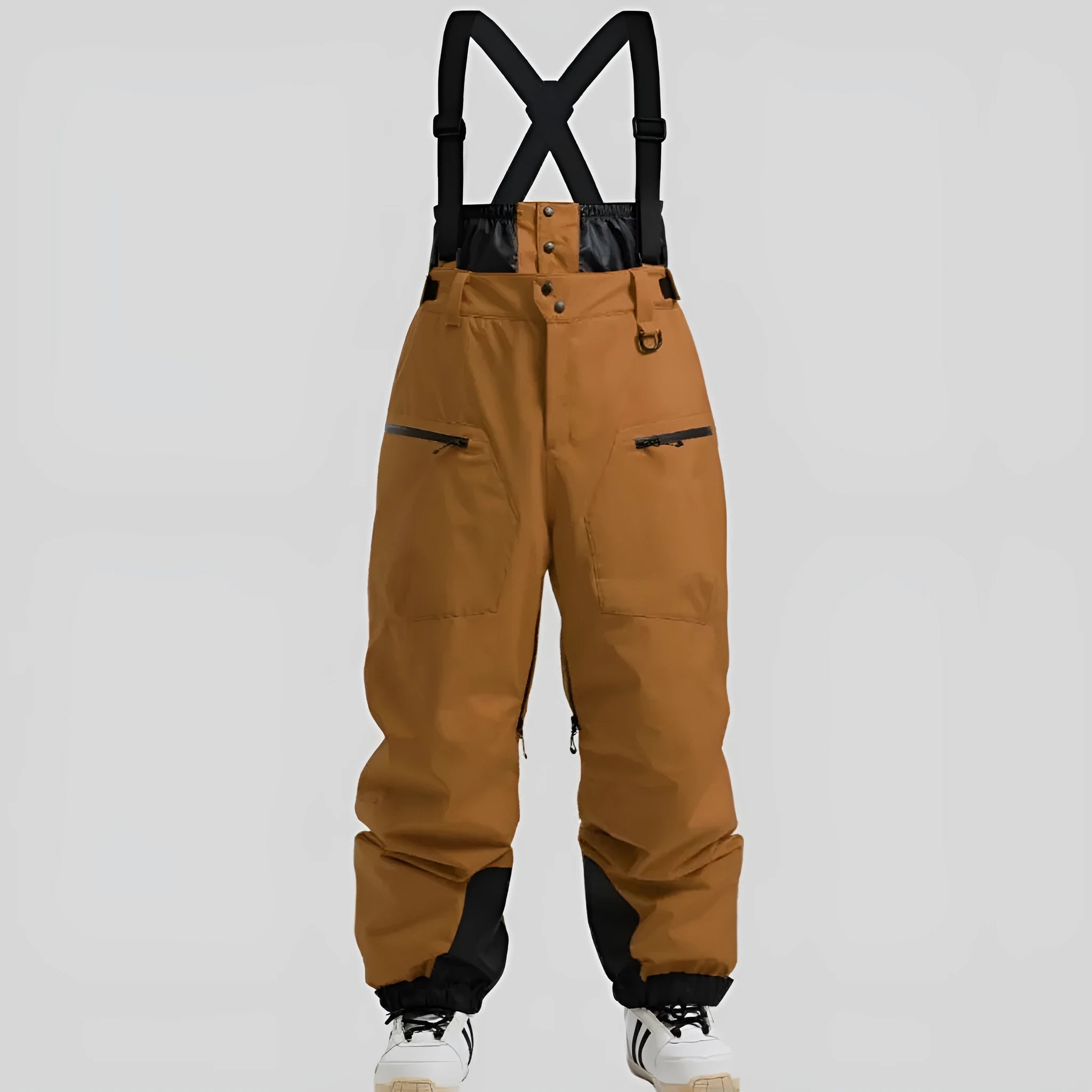 Man wearing black waterproof ski trousers with an adjustable strap, on a ski slope.