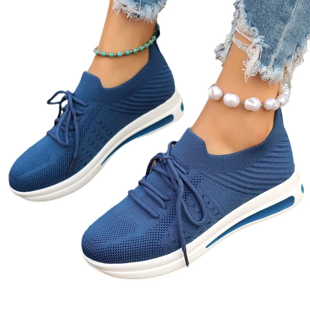 Women's low-top casual sneakers in black, blue, and red with a fly-knit style PU upper and lace-up front.