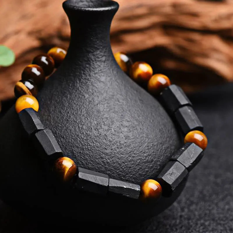Natural obsidian single ring bracelet with 8mm beads and a metal constellation charm on a white background.