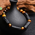Natural obsidian single ring bracelet with 8mm beads and a metal constellation charm on a white background.