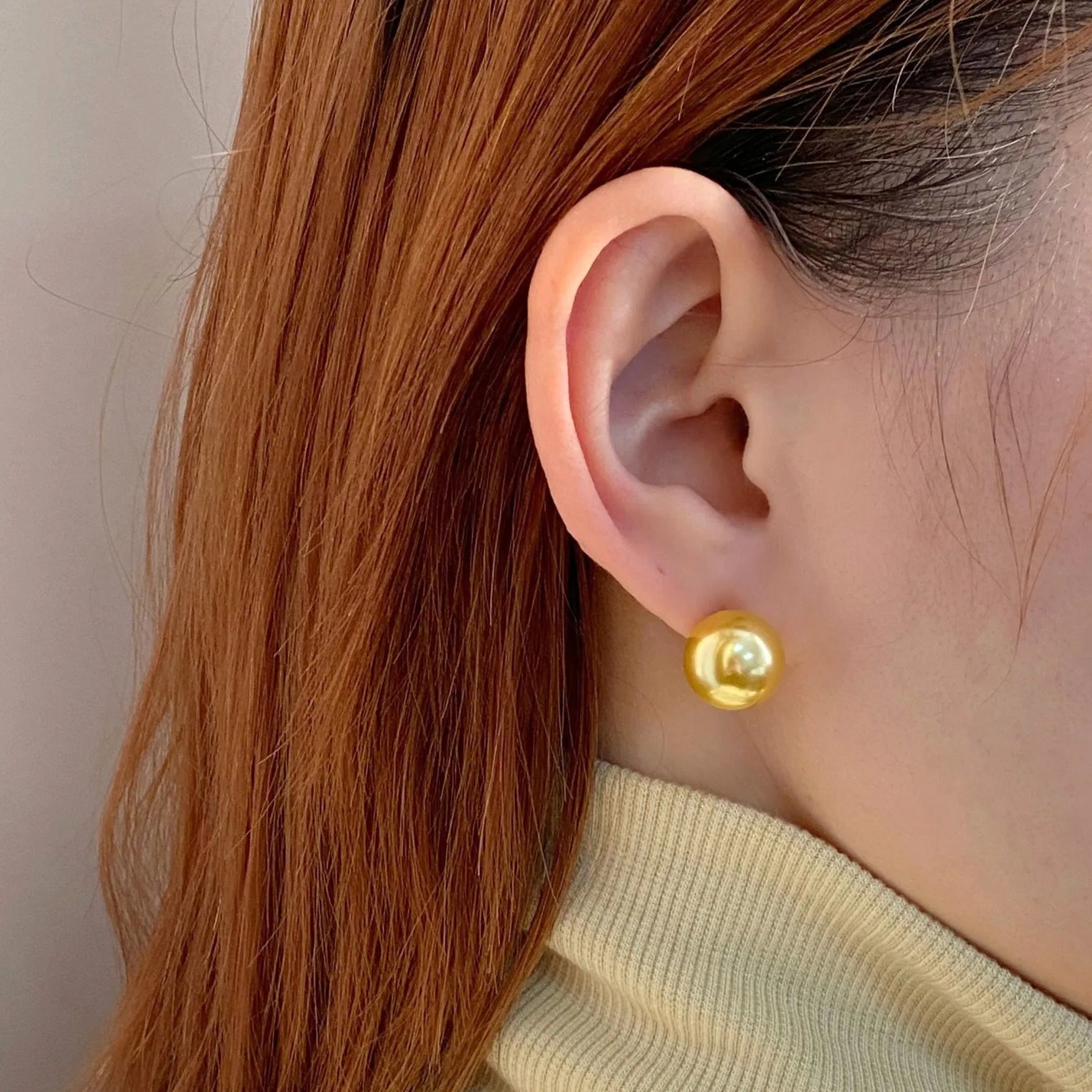 A pair of large geometric pearl stud earrings with an eight-awn star detail on silver settings.