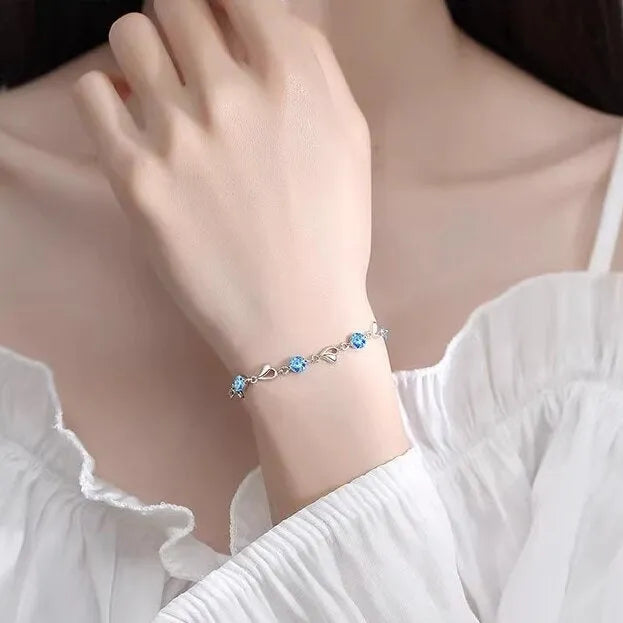 Blue diamond electroplated heart necklace and bracelet set with gem inlay on a geometric pendant.