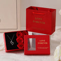 Korean style gift box open to show six red soap flowers, with a handbag beside it.