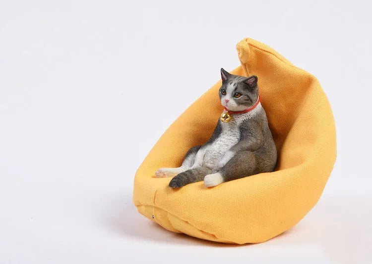Small resin ornament of a cat sleeping on a sofa for car dashboard or shelf decoration.