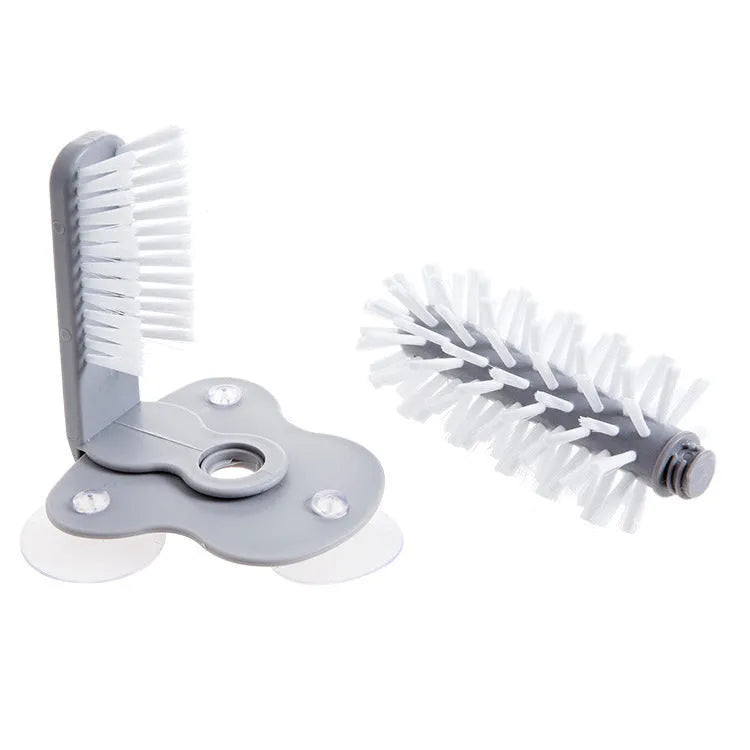 Grey 2 in 1 cup scrubber with double-sided bristles and three suction cups on the base for cleaning glassware.